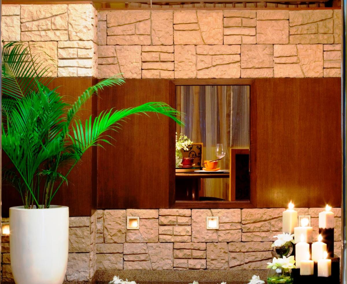a room with a potted plant and candles at Blue Diamond Pune IHCL SeleQtions in Pune