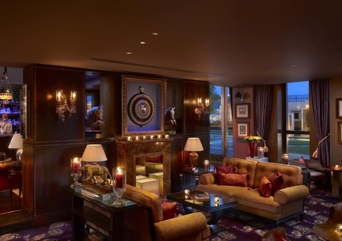 a living room with a couch and a fireplace at The Leela Palace Udaipur in Udaipur