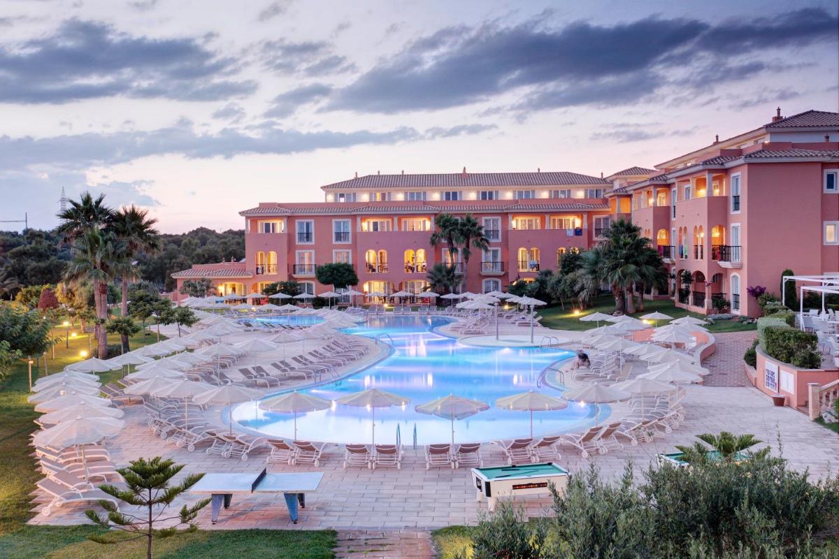 un complejo con una gran piscina con sombrillas en Grupotel Macarella Suites & Spa, en Son Xoriguer 41 fotos más