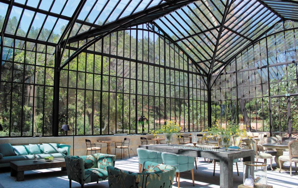 - une véranda avec une table et des chaises dans l'établissement Domaine De Manville, aux Baux-de-Provence