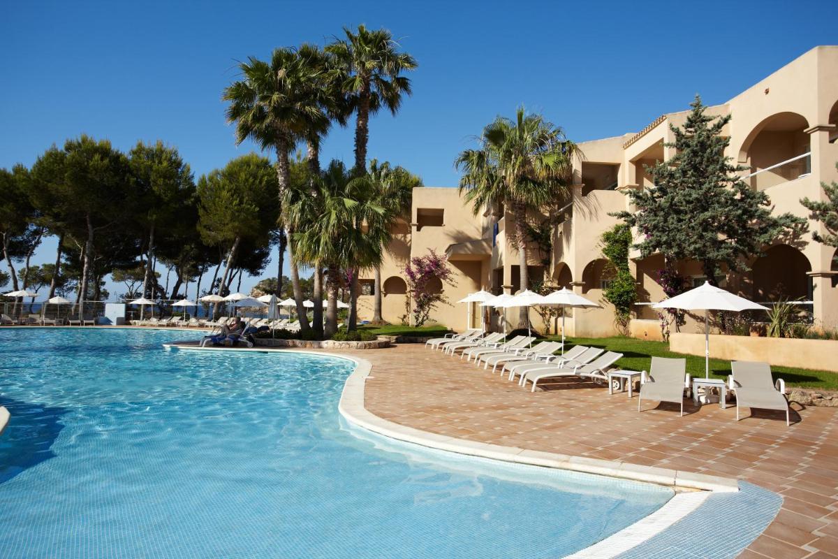 una piscina en un resort con sillas y sombrillas en Grupotel Santa Eulària & Spa - Adults Only, en Santa Eulària des Riu