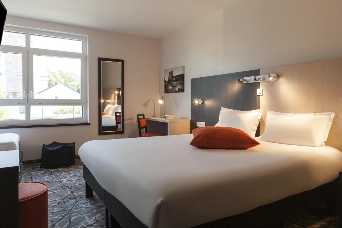 une chambre avec un grand lit blanc avec une fenêtre dans l'établissement The Originals Boutique, Hôtel d'Alsace, Strasbourg Sud, à Illkirch-Graffenstaden