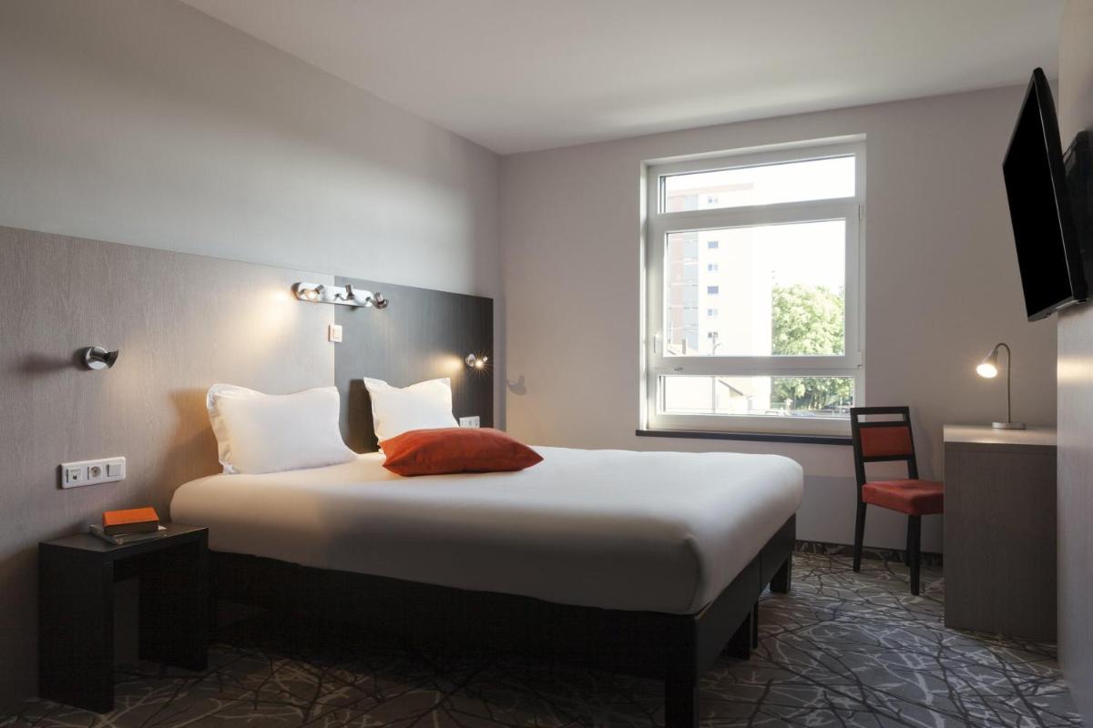 une chambre avec un grand lit et une fenêtre dans l'établissement The Originals Boutique, Hôtel d'Alsace, Strasbourg Sud, à Illkirch-Graffenstaden
