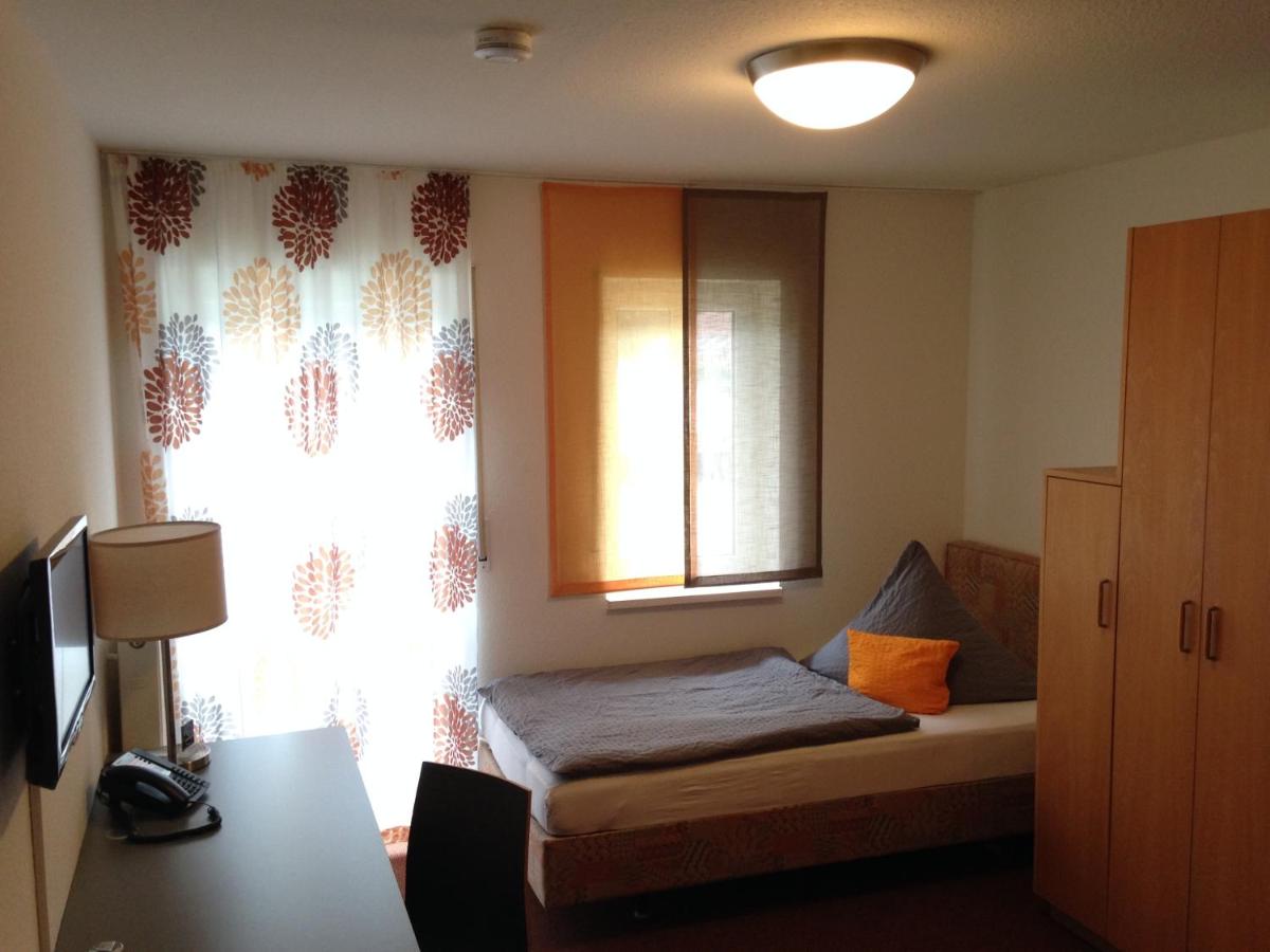 ein kleines Schlafzimmer mit einem Bett und einem Fenster in der Unterkunft Hotel Astra Rastatt in Rastatt ein kleines Schlafzimmer mit einem Bett und einem Fenster in der Unterkunft Hotel Astra Rastatt in Rastatt