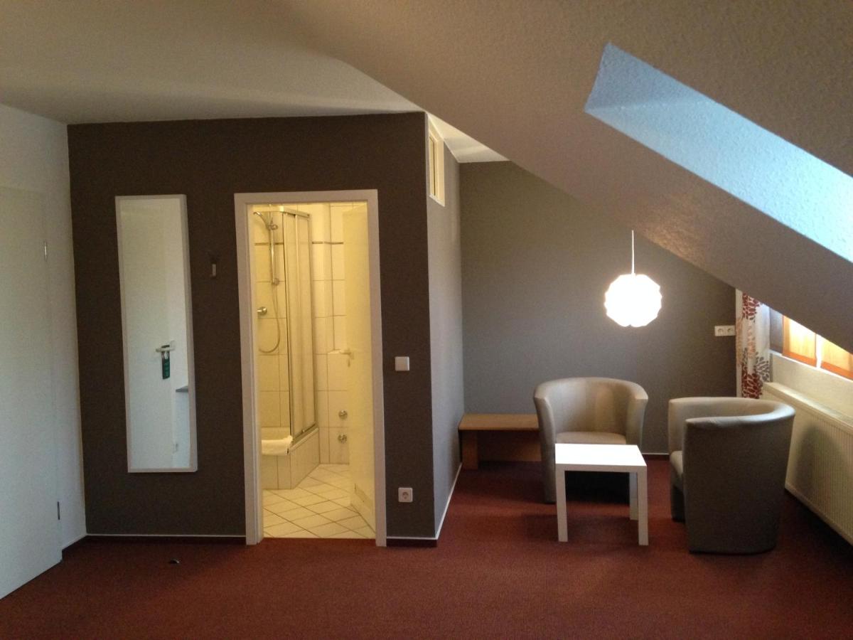 ein Wohnzimmer mit Tisch und Stühlen und ein Dachboden in der Unterkunft Hotel Astra Rastatt in Rastatt + 29 Fotos