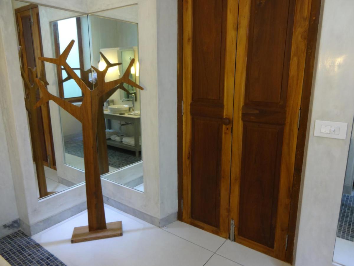 a room with a mirror and a statue of a tree at La Villa in Puducherry