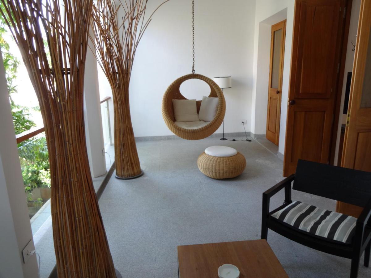 a living room with trees and a mirror at La Villa in Puducherry