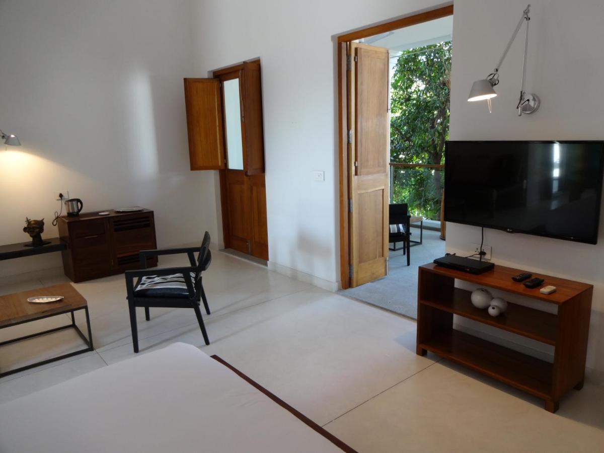 a living room with a large flat screen tv at La Villa in Puducherry