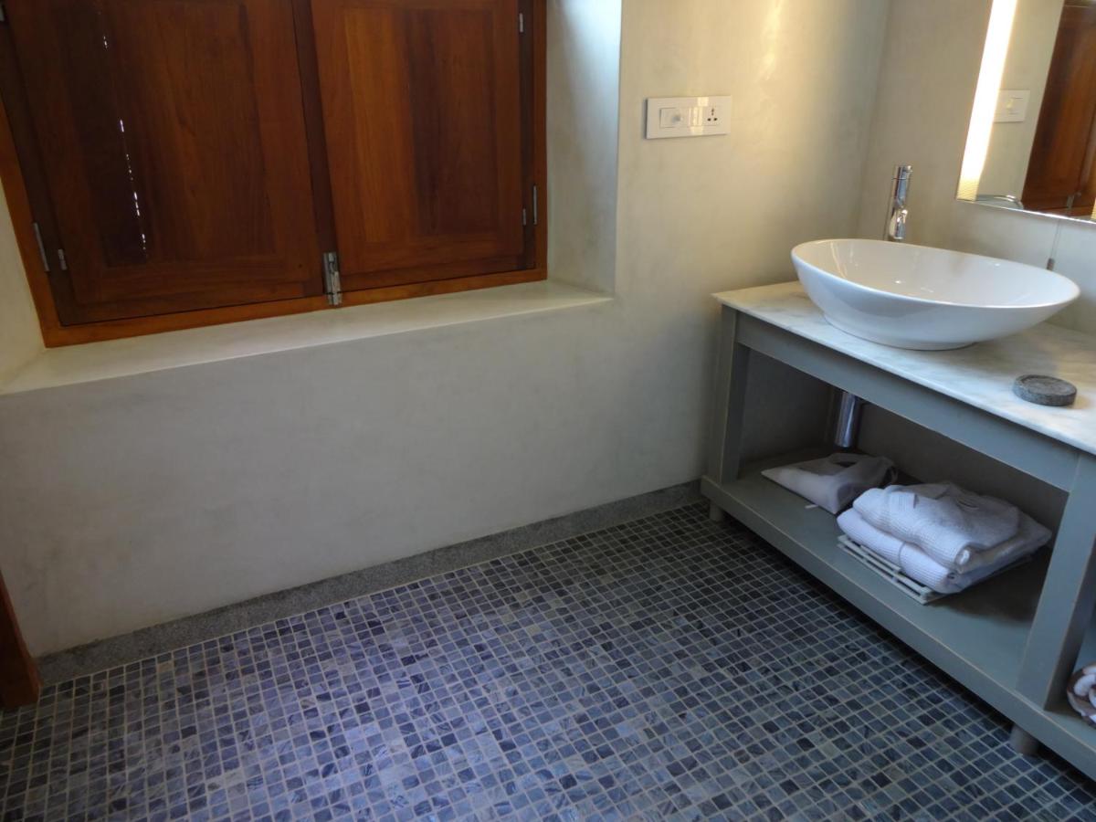 a bathroom with a sink and a counter with towels at La Villa in Puducherry