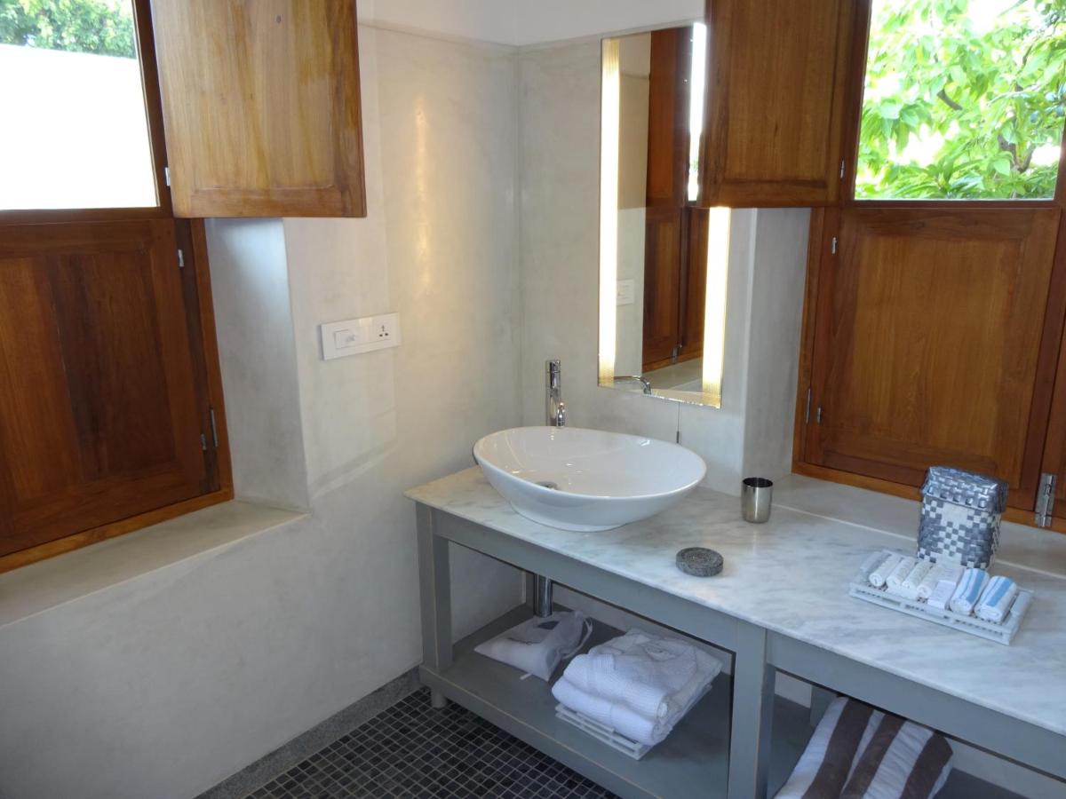 a bathroom with a white sink and a counter at La Villa in Puducherry