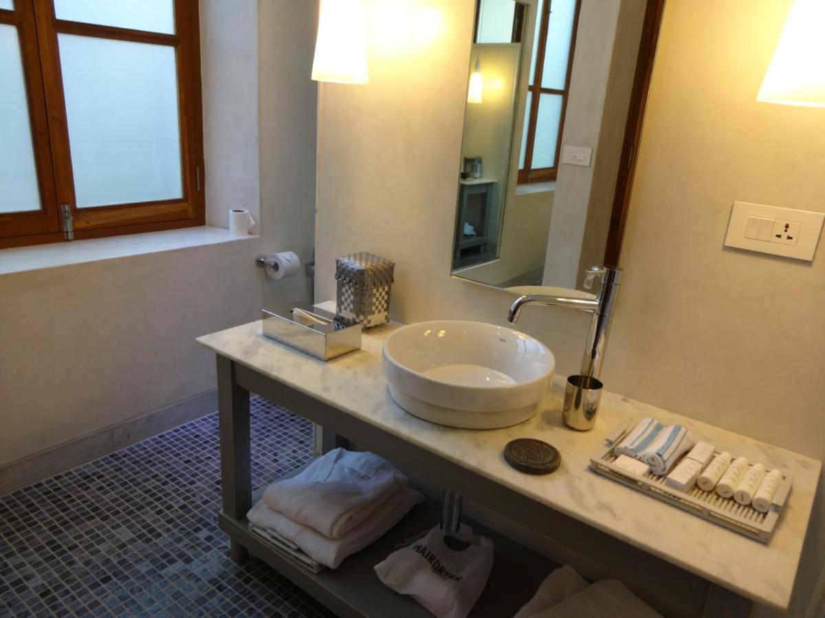 a bathroom with a sink and a large mirror at La Villa in Puducherry