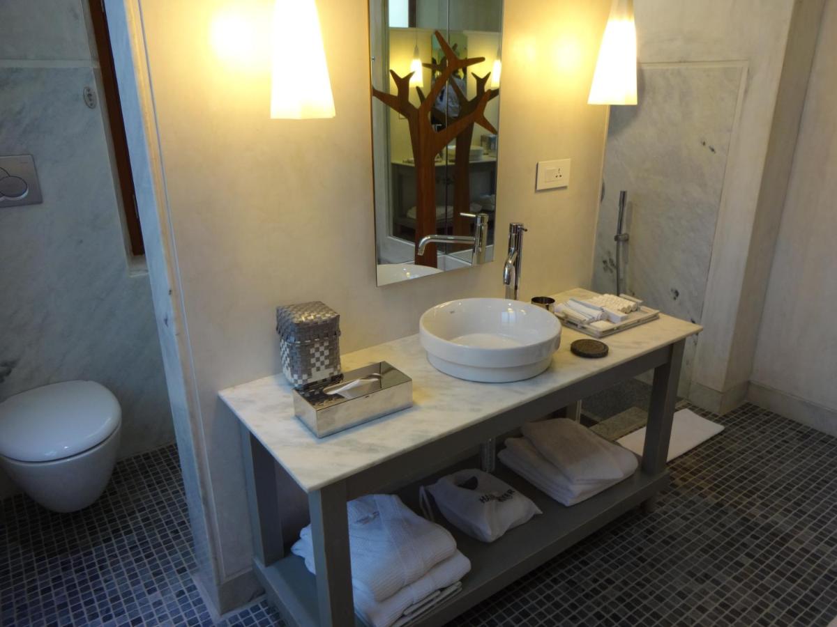 a bathroom with a sink and a toilet and a mirror at La Villa in Puducherry