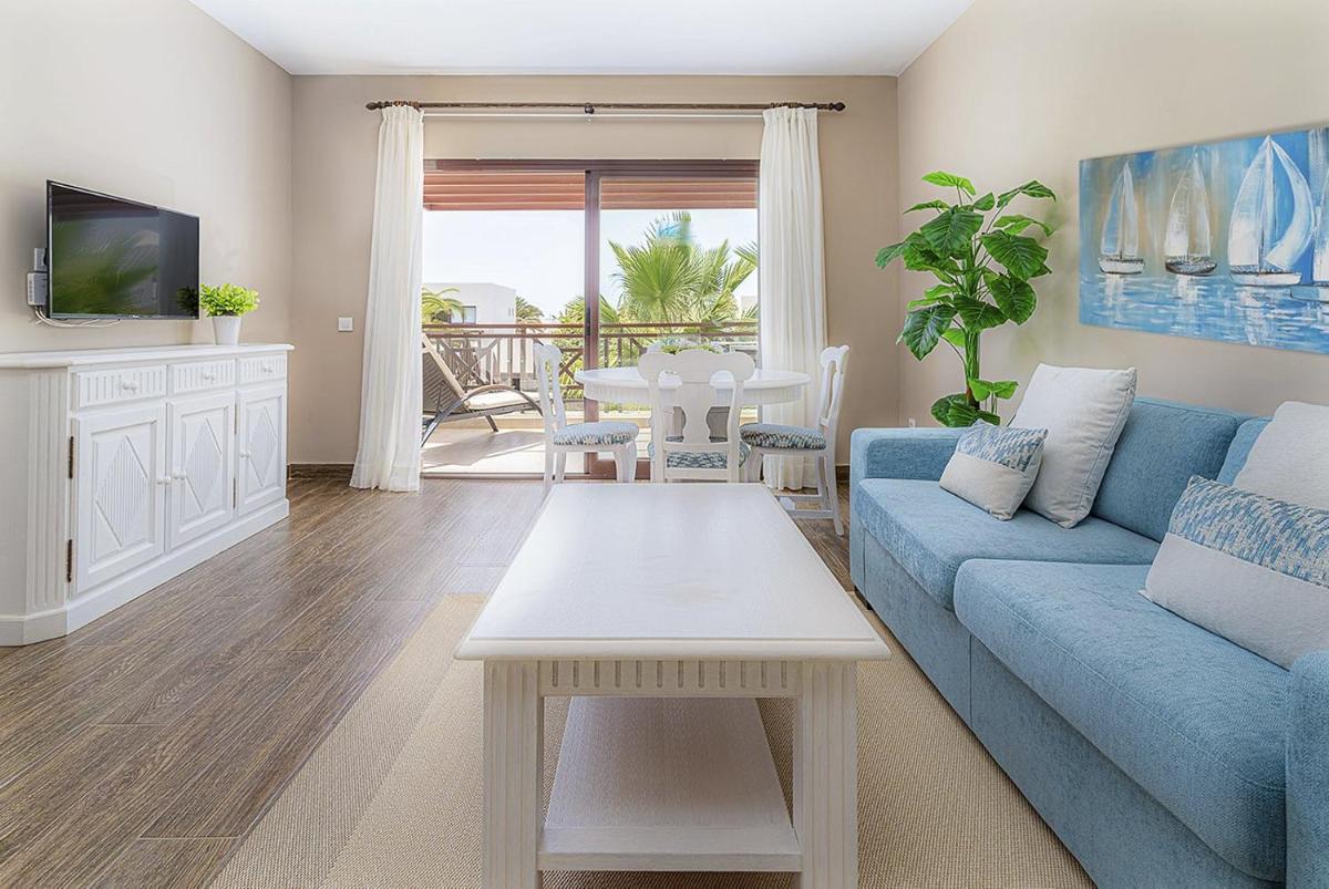 Una sala de estar con un sofá azul y una mesa. en LANZAROTE PRIME SPORTS by Vitalclass Lanzarote Resort, en Costa Teguise