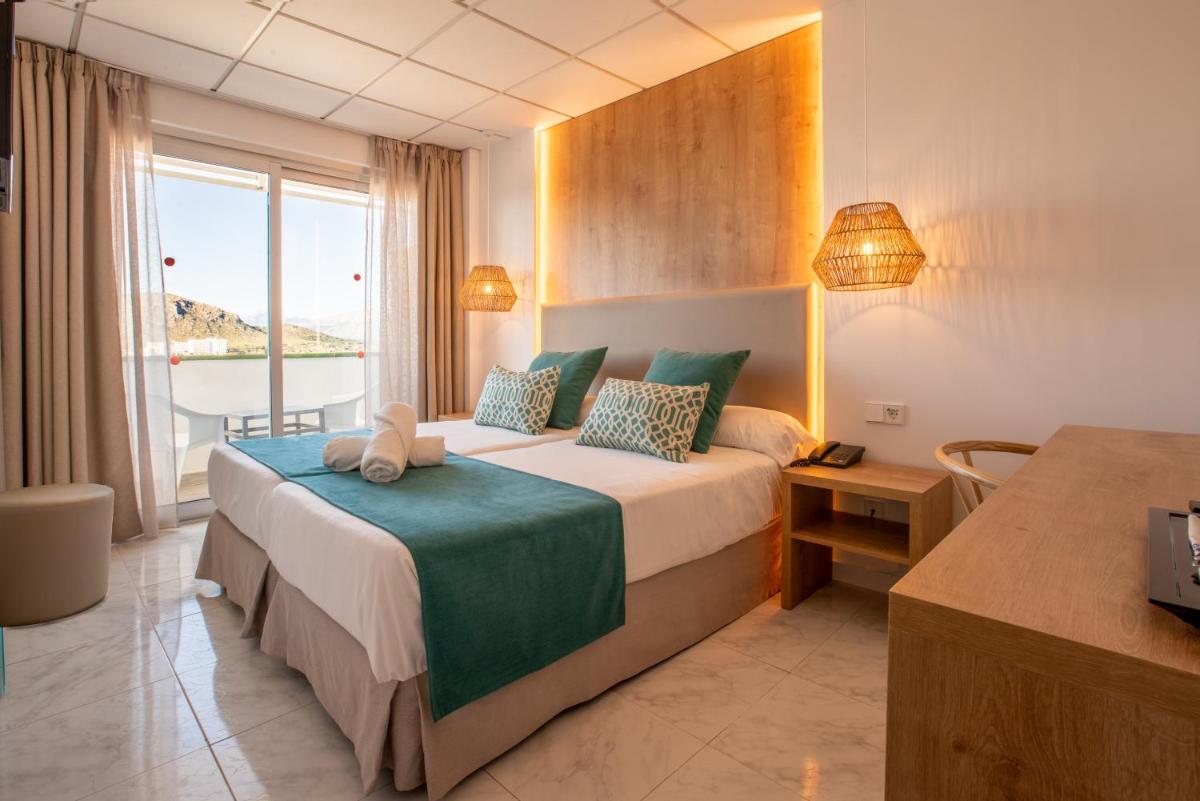Una habitación de hotel con una cama grande y una ventana. en Bahía de Alcudia Hotel & Spa, en Puerto de Alcudia 66 fotos más