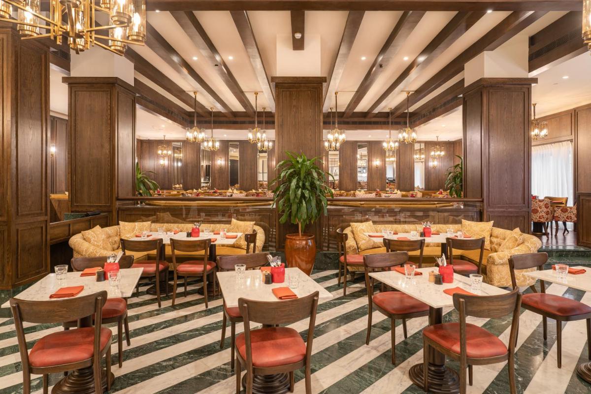 a restaurant with tables and chairs and a bar at President - IHCL SeleQtions in Mumbai