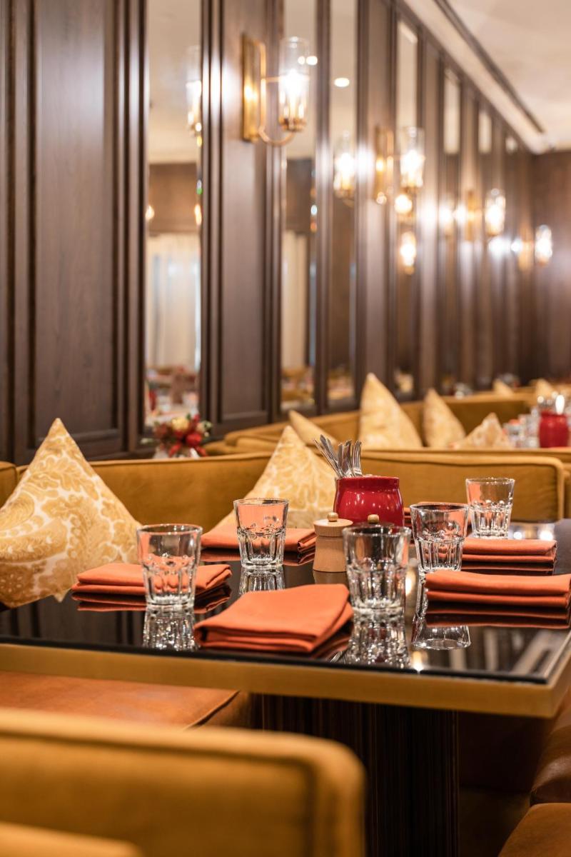 a dining room with a table with glasses and napkins at President - IHCL SeleQtions in Mumbai