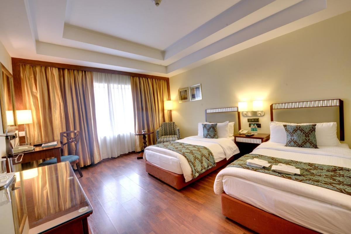 a hotel room with two beds and a television at Fortune Select JP Cosmos, Bengaluru - Member ITC Hotels' Group in Bengaluru