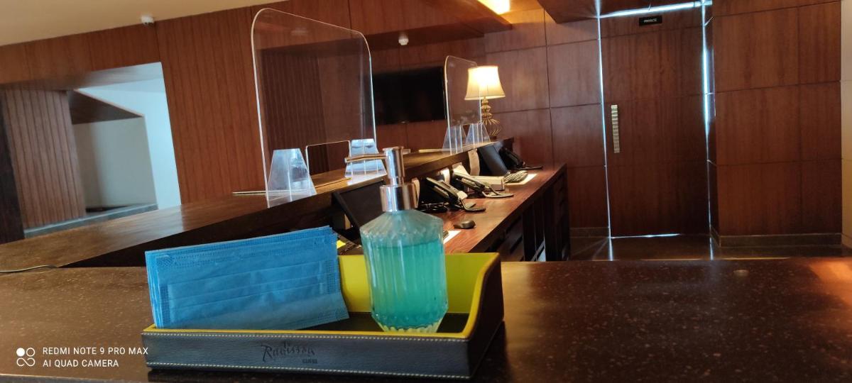 a kitchen with a counter with a sink and a mirror at Radisson Kufri in Shimla