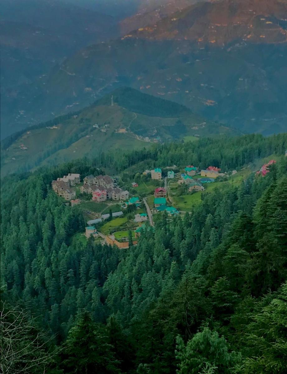 a village in the middle of a forest of trees at Radisson Kufri in Shimla