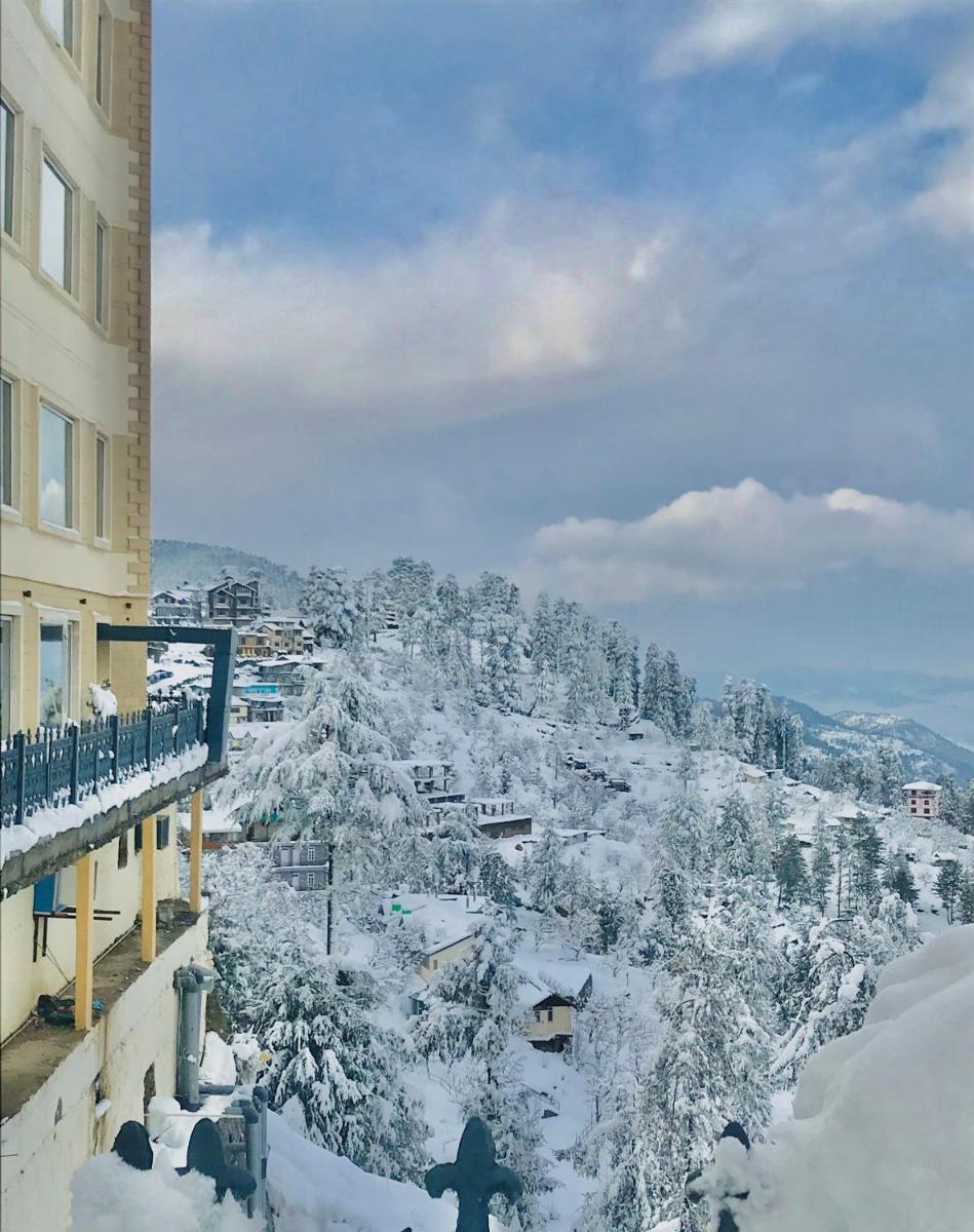 a person standing on a balcony in the snow at Radisson Kufri in Shimla