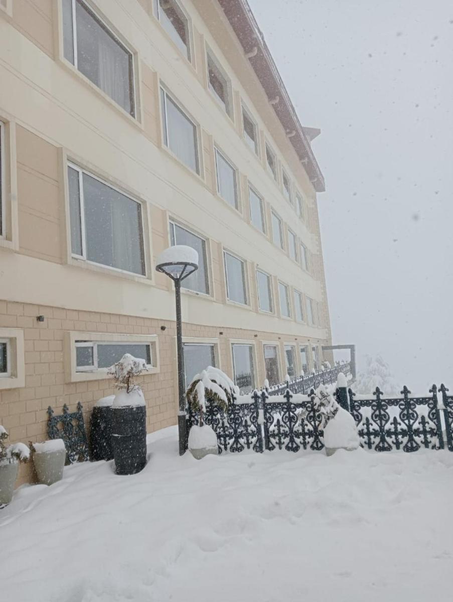 a building with a snow covered fence in front of it at Radisson Kufri in Shimla