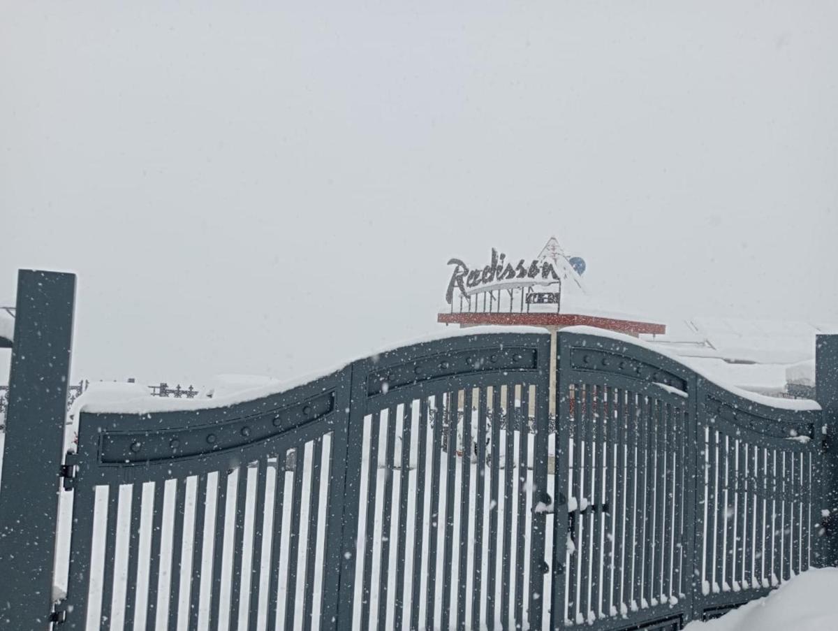 a fence with a sign on top of it in the snow at Radisson Kufri in Shimla