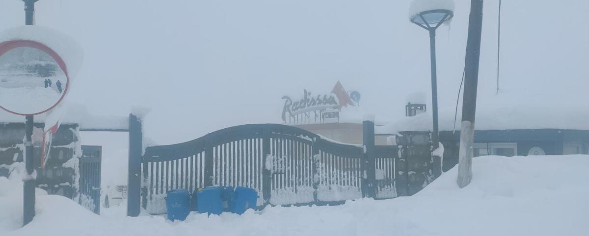 a fence covered in snow next to a street light at Radisson Kufri in Shimla