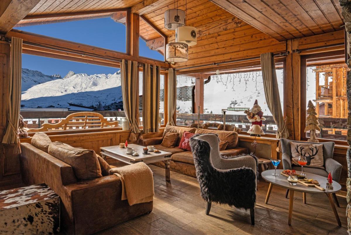 un salon avec des canapés et une vue sur une montagne dans l'établissement Hôtel les Campanules by Les Etincelles, à Tignes