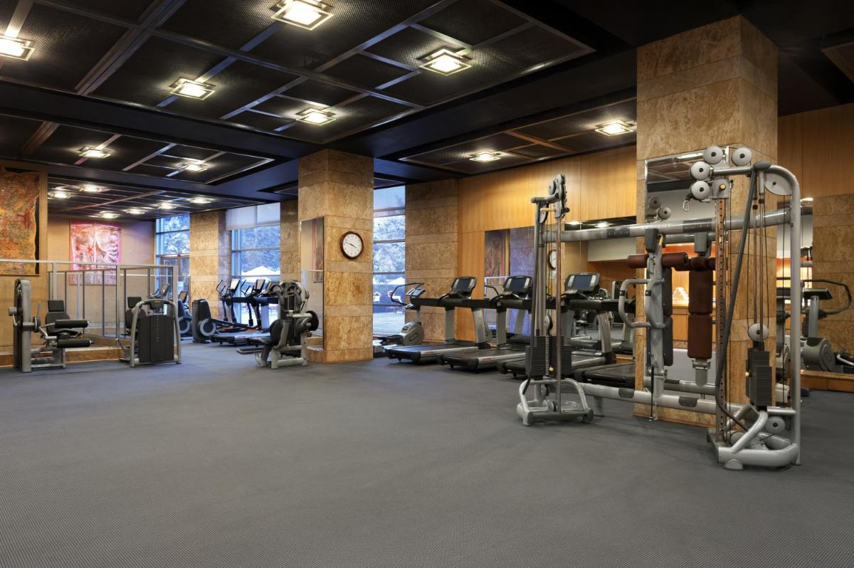 a gym with several treadmills and weights at Grand Hyatt Mumbai Hotel and Residences in Mumbai