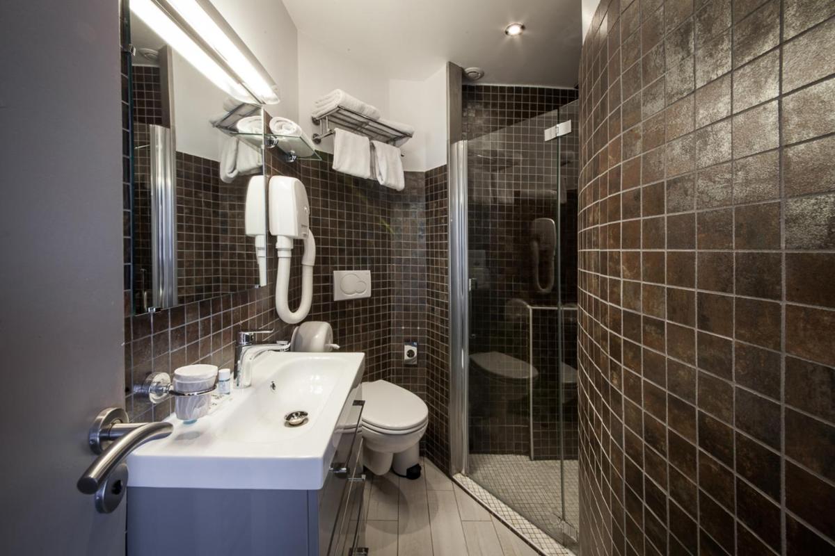 une salle de bain avec un lavabo, des toilettes et une douche dans l'établissement Hotel SPA Plage St Jean, à La Ciotat