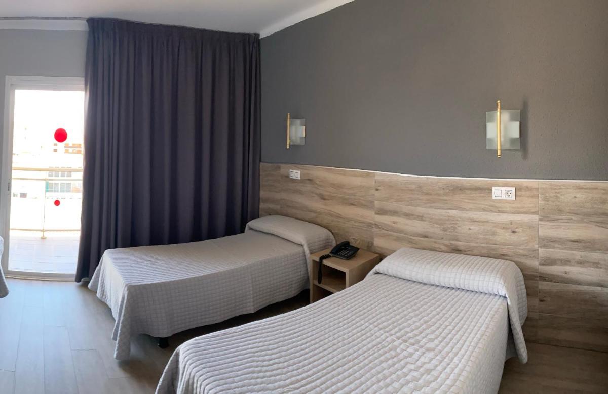 Una habitación de hotel con dos camas y una ventana. en Hotel Reymar, en Malgrat de Mar