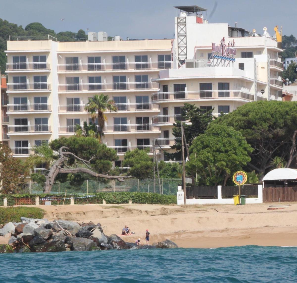 un gran hotel en la playa con gente en la playa en Hotel Reymar, en Malgrat de Mar