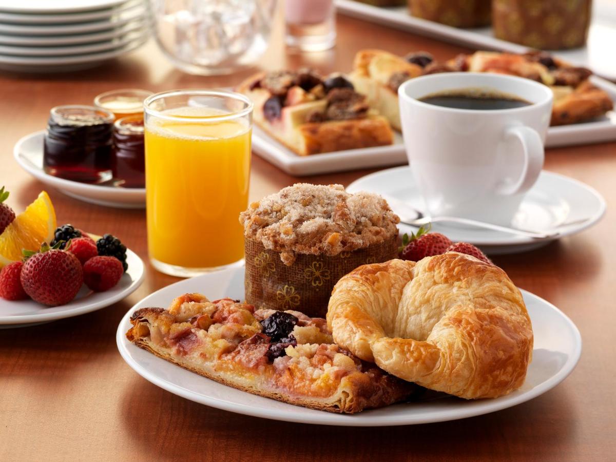a table with plates of breakfast foods and a cup of coffee at Hyatt Regency Dehradun Resort and Spa in Dehradun