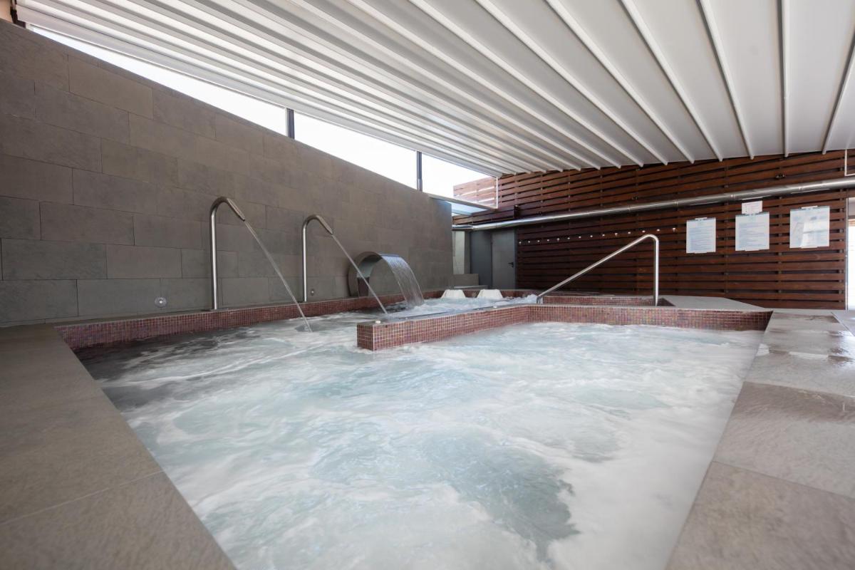bañera de hidromasaje grande en un edificio con agua en Hotel Thalasso Cantabrico Las Sirenas 4 Superior, en Viveiro