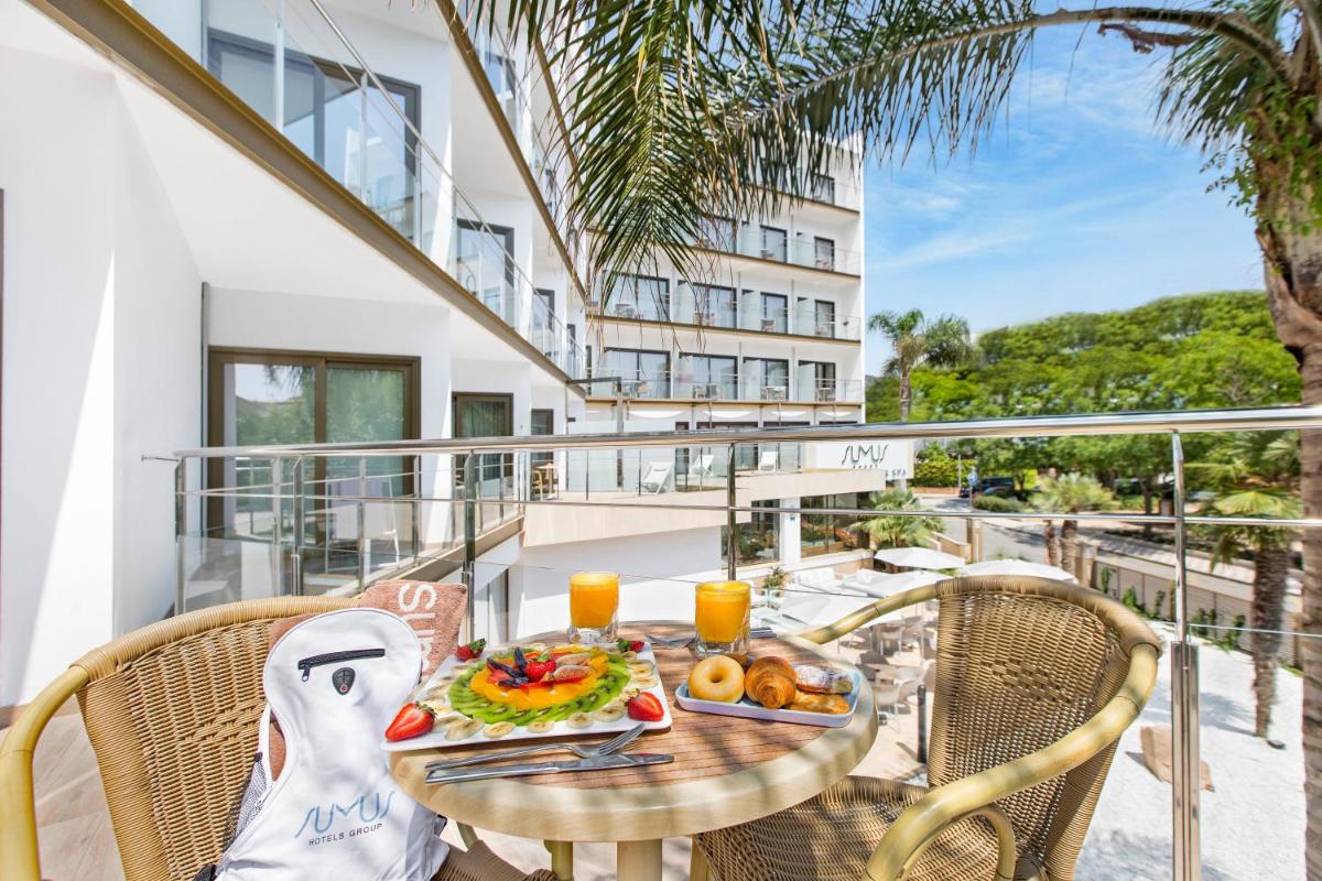 Una mesa con comida y bebidas en un balcón. en Sumus Hotel Stella and Spa 4S Adults Recommended, en Pineda de Mar
