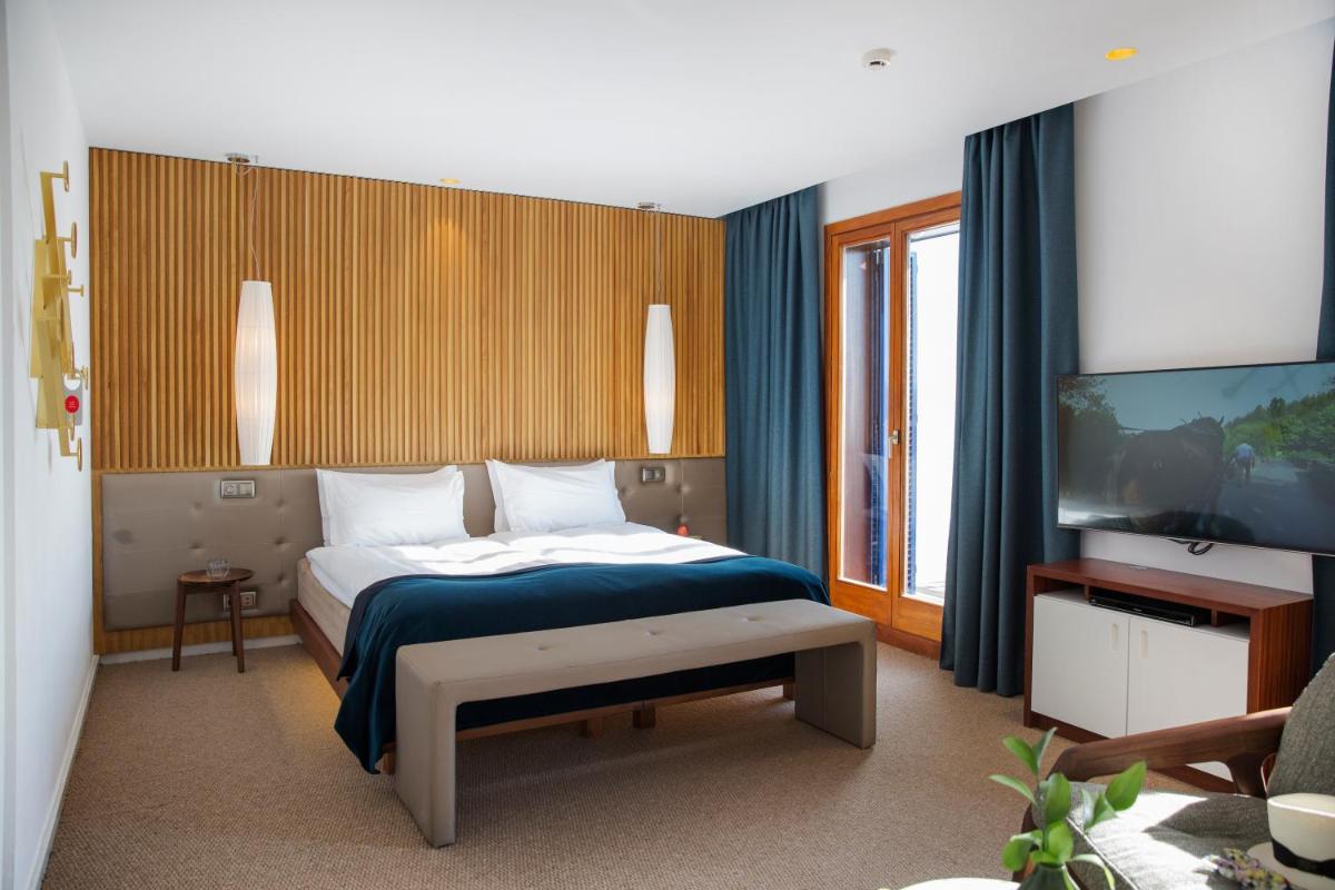 Un dormitorio con una cama y un televisor en una habitación. en Portixol Hotel & Restaurant, en Palma de Mallorca