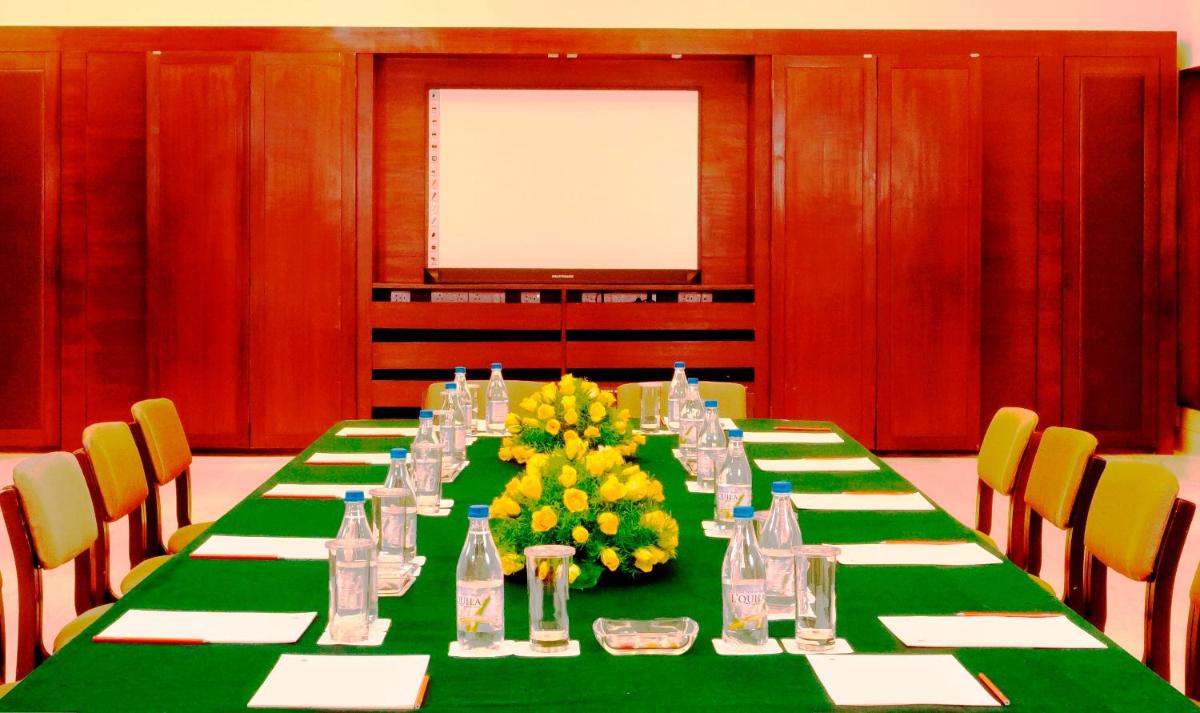 a conference room with a long table with yellow flowers at Trident Agra in Agra
