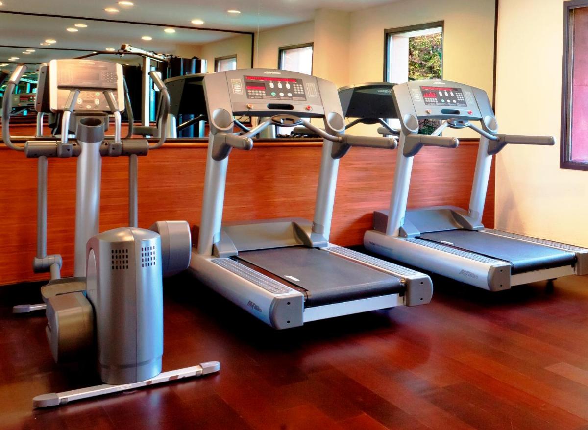 two treadmill machines in a gym with wood floors at Trident Agra in Agra
