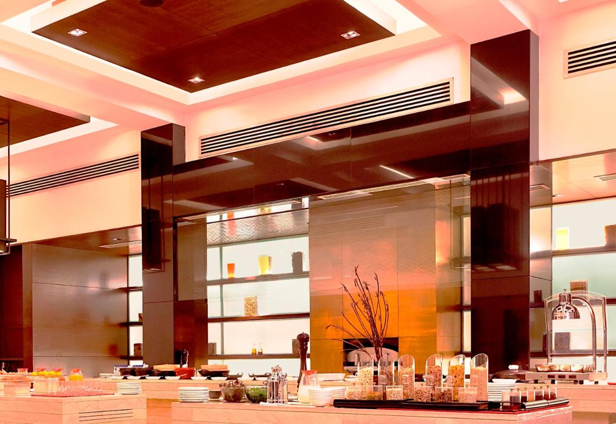 a restaurant with a display case in a room at Trident Agra in Agra