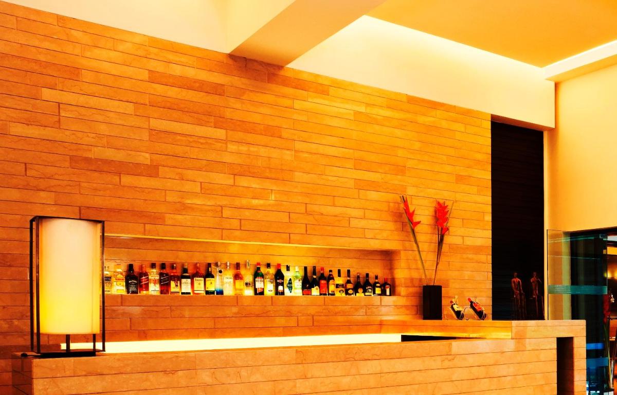 a wall with a bar with bottles on it at Trident Agra in Agra
