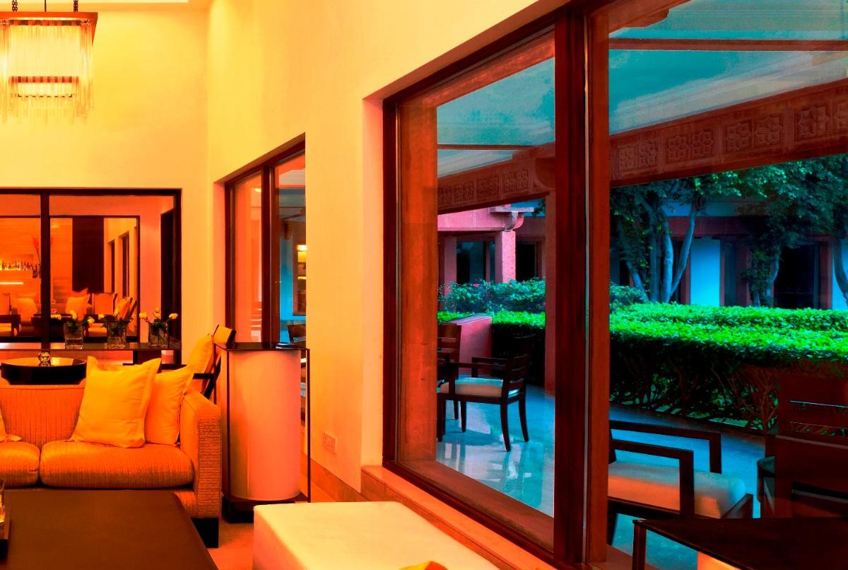 a living room with a couch and a balcony with a garden at Trident Agra in Agra