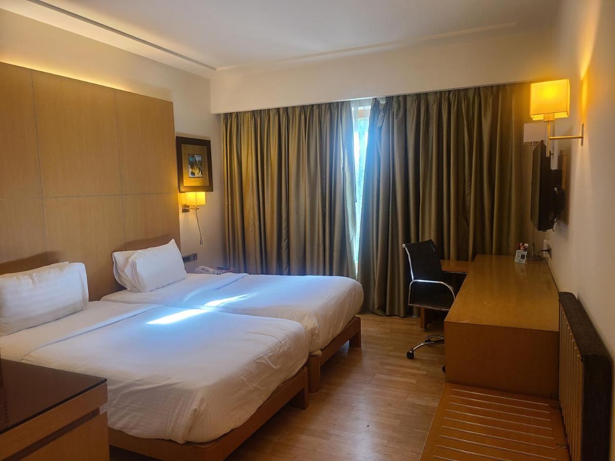 a hotel room with a large bed and a desk at Novotel Hyderabad Airport in Hyderabad