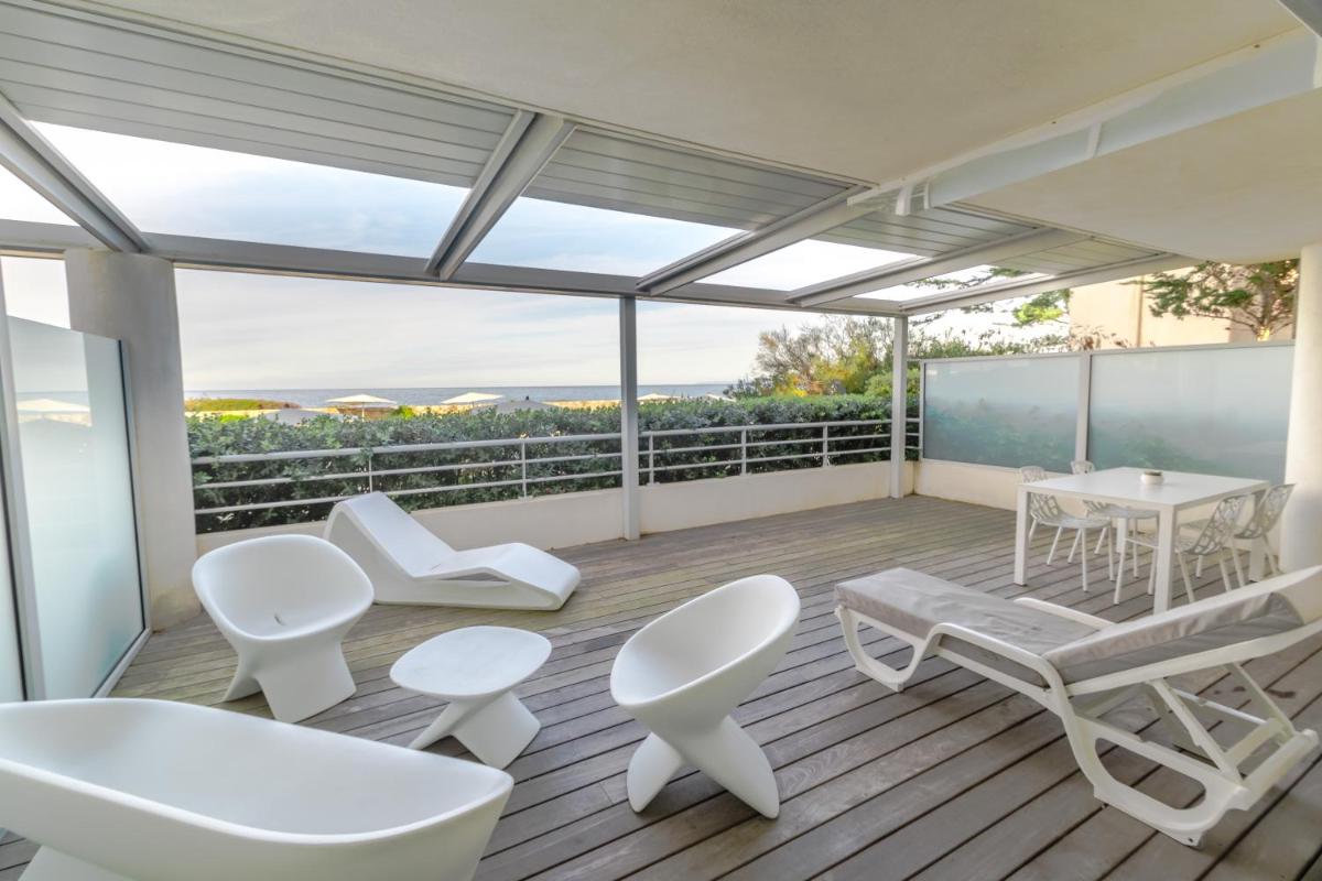 Elle comprend un balcon doté d'un mobilier blanc, d'une table et de chaises. dans l'établissement Résidence Dary, à LʼÎle-Rousse