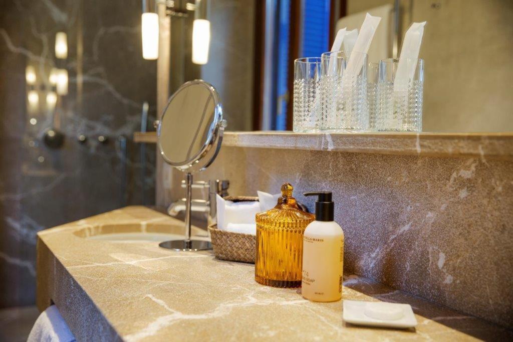 un lavabo con una botella de jabón y un espejo en Portixol Hotel & Restaurant, en Palma de Mallorca