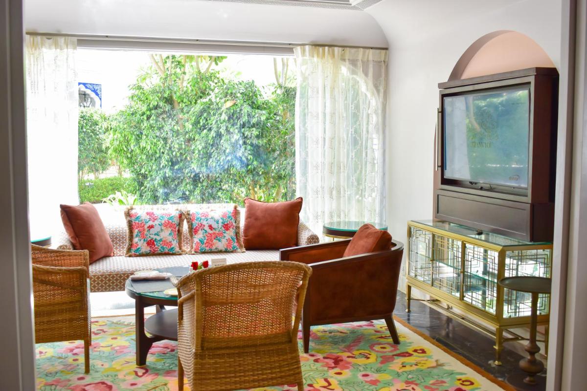 a living room with a couch and a tv at The Leela Palace Jaipur in Jaipur