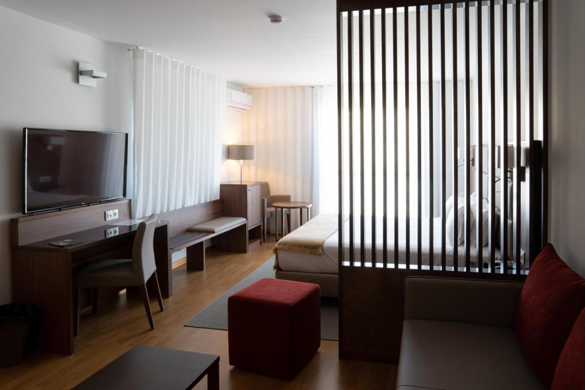 uma sala de estar com um sofá e uma TV em Hotel Freixo Douro Superior em Freixo de Espada à Cinta