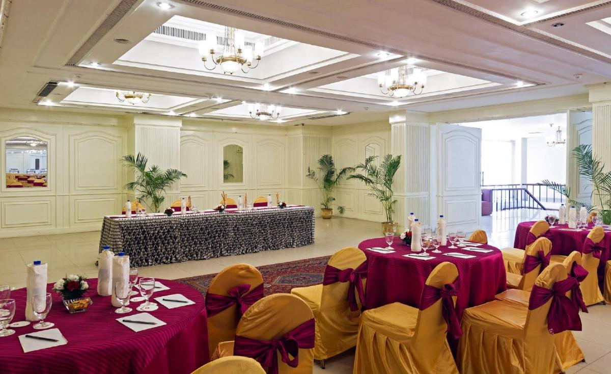 a banquet hall with purple tables and yellow chairs at Clarks Avadh in Lucknow