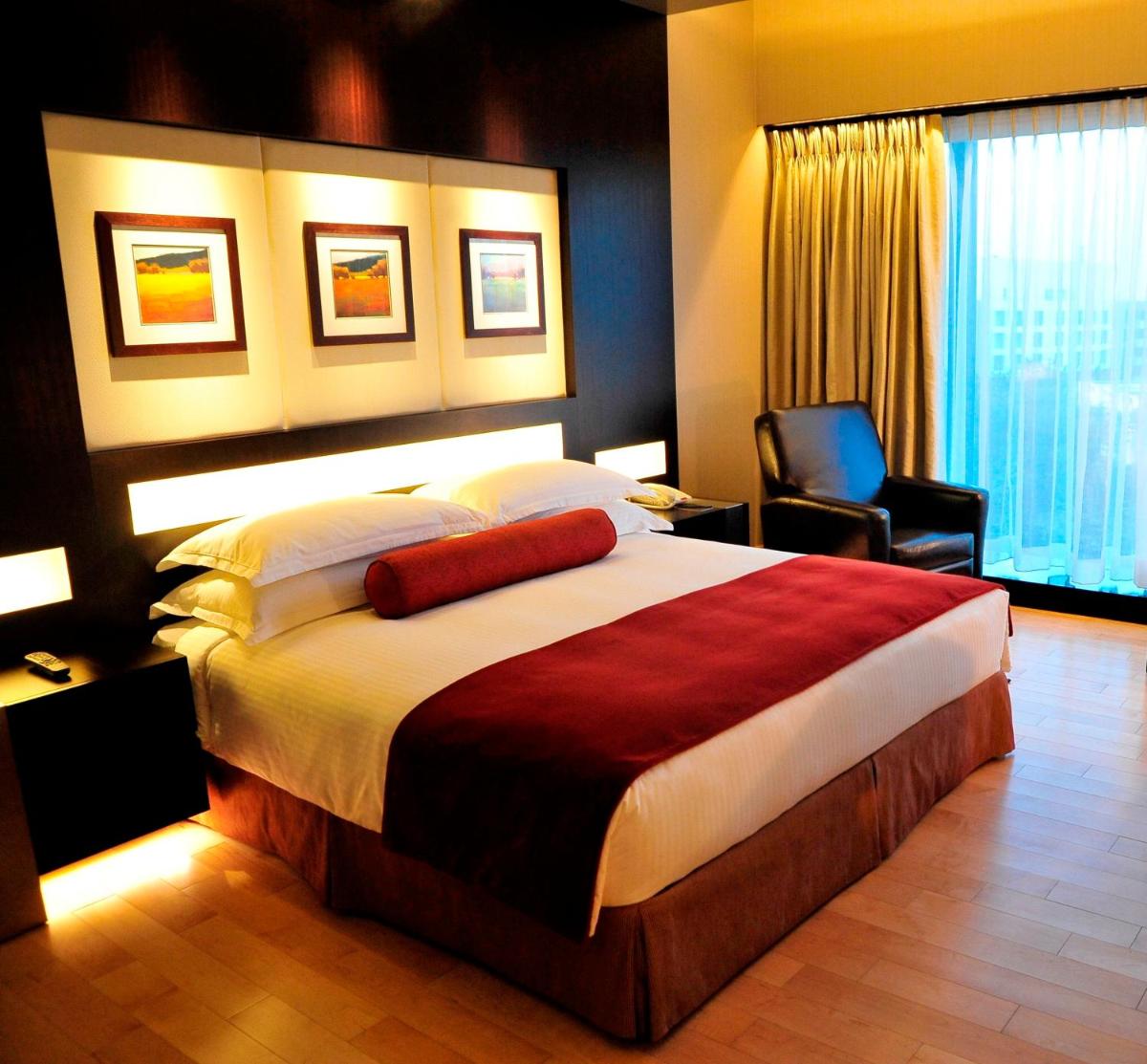 a hotel room with a large bed and a chair at The Oterra in Bengaluru