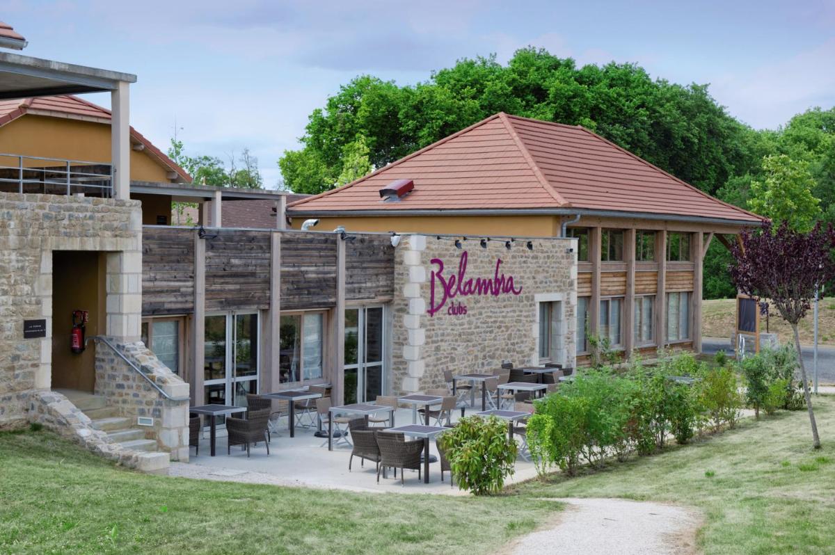 un restaurant avec des tables et des chaises devant un bâtiment dans l'établissement Belambra Clubs Résidence Rocamadour - Les Portes De Dordogne, à Alvignac