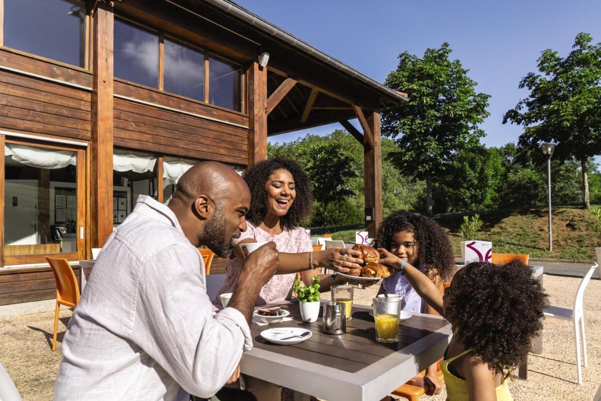 un groupe de personnes assises à une table en train de manger dans l'établissement Belambra Clubs Résidence Rocamadour - Les Portes De Dordogne, à Alvignac
